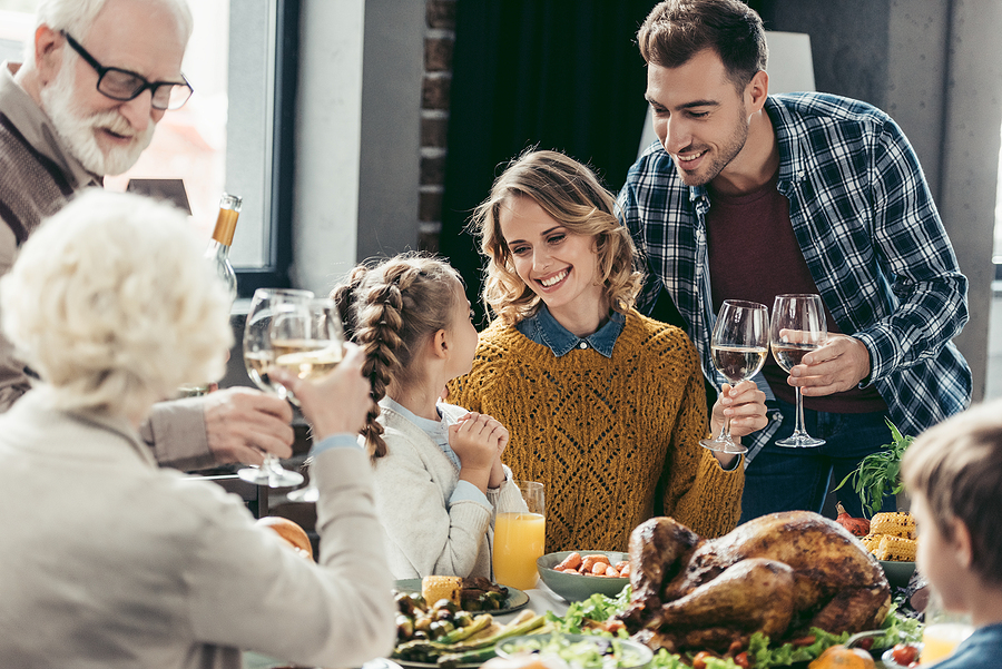 happy large family having holiday dinner on thanksgiving day